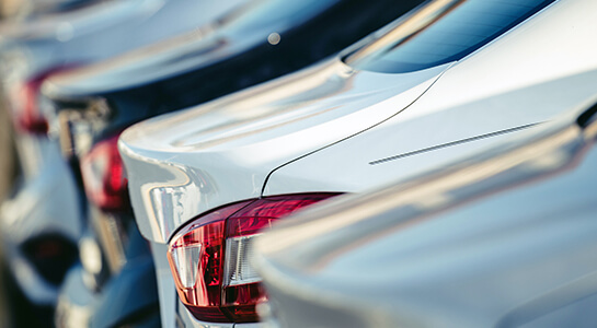 Side-rear view of sedan cars lined up in a vehicle dealer's lot